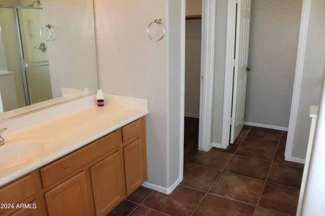 bathroom featuring tile patterned flooring, vanity, and a shower with door