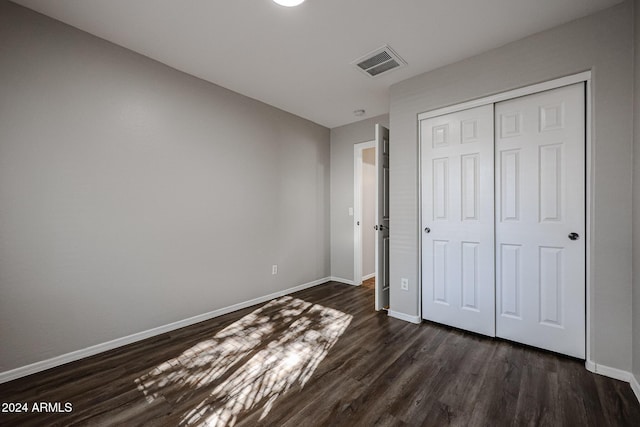 41208 W Bravo Dr, Maricopa, AZ 85138 - unfurnished bedroom featuring dark wood finished floors, baseboards, and a closet