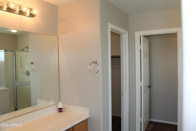 bathroom featuring tile patterned flooring, vanity, and a shower with shower door