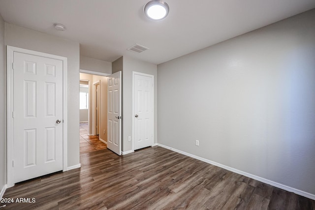 41208 W Bravo Dr, Maricopa, AZ 85138 - unfurnished bedroom featuring dark wood-style floors, baseboards, and a closet