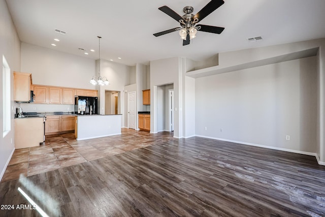 41208 W Bravo Dr, Maricopa, AZ 85138 - unfurnished living room with a chandelier, ceiling fan, recessed lighting, dark wood-style flooring, and a high ceiling