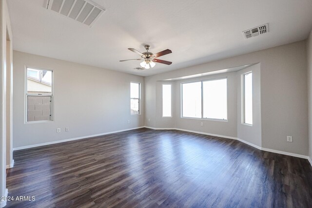 41208 W Bravo Dr, Maricopa, AZ 85138 - unfurnished room featuring plenty of natural light, baseboards, ceiling fan, and dark wood-type flooring