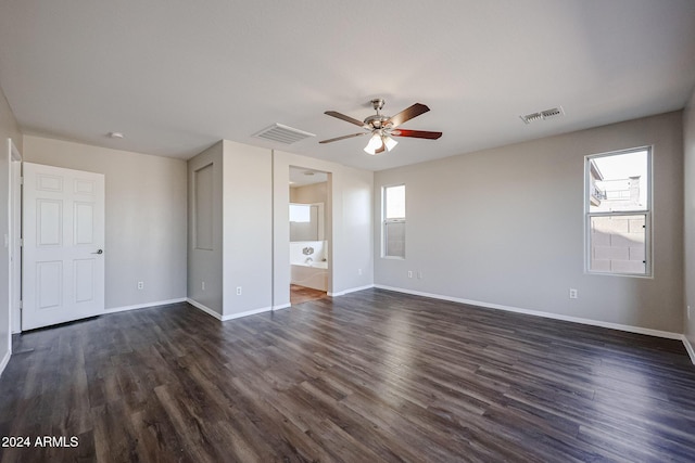 41208 W Bravo Dr, Maricopa, AZ 85138 - unfurnished bedroom with baseboards, dark wood-style floors, ensuite bathroom, and ceiling fan