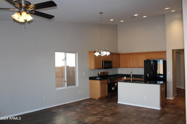 kitchen with a kitchen island with sink, high vaulted ceiling, black appliances, ceiling fan with notable chandelier, and hanging light fixtures