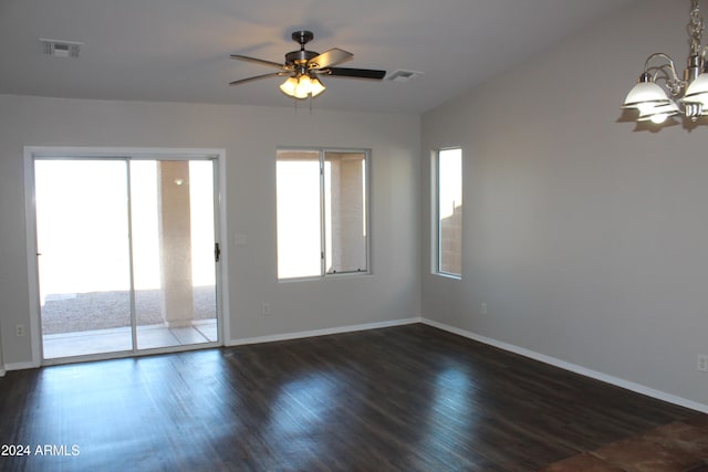 unfurnished room featuring plenty of natural light, lofted ceiling, dark wood-type flooring, and ceiling fan with notable chandelier