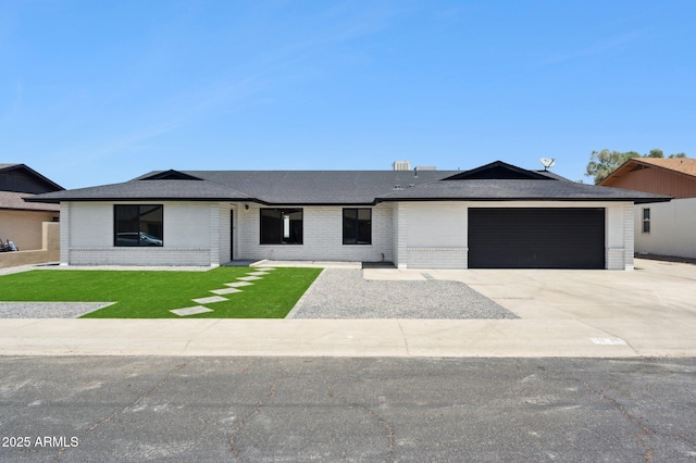 ranch-style home featuring brick siding, a garage, driveway, and a shingled roof