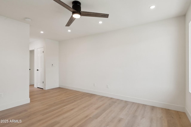 spare room with recessed lighting, light wood-style floors, baseboards, a ceiling fan, and a smoke detector