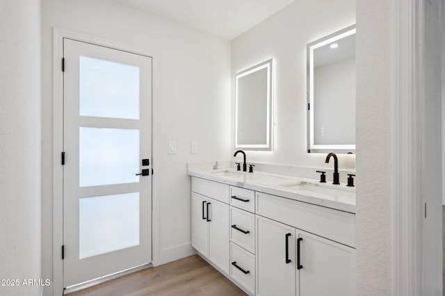full bathroom featuring double vanity and wood finished floors