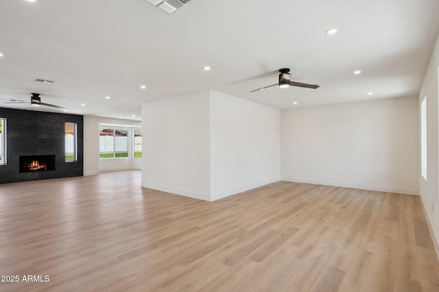 unfurnished living room featuring ceiling fan, light wood-style floors, recessed lighting, and baseboards