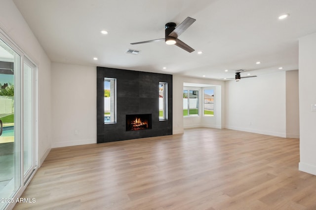 unfurnished living room with ceiling fan, recessed lighting, a fireplace, light wood-type flooring, and baseboards