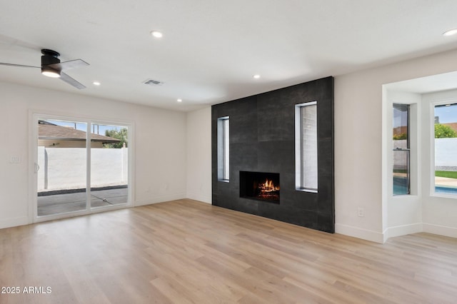 unfurnished living room featuring light wood-type flooring, a fireplace, recessed lighting, baseboards, and ceiling fan