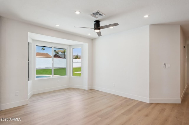 empty room with light wood finished floors, ceiling fan, baseboards, and recessed lighting