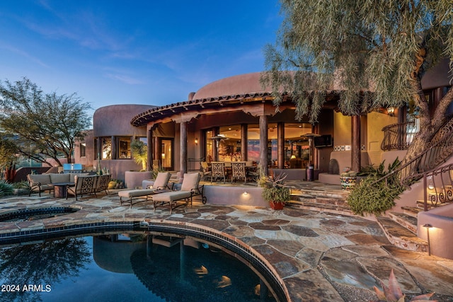 pool at dusk with an outdoor living space and a patio