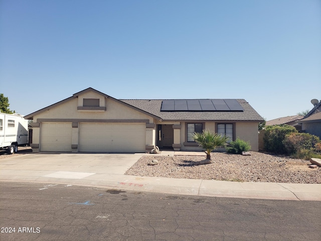 view of front of home featuring solar panels and a garage