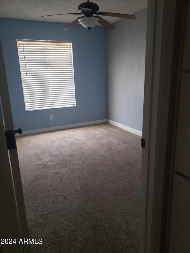 carpeted empty room featuring a textured ceiling and ceiling fan