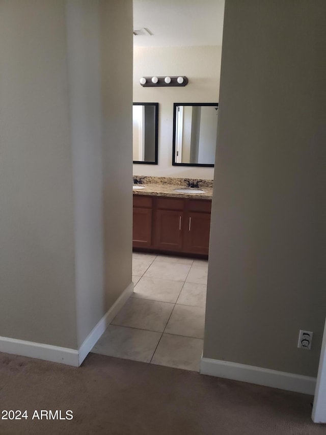 hall with light tile patterned flooring and sink