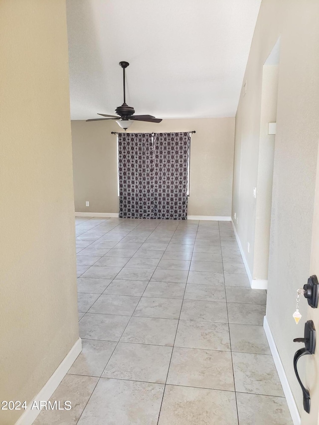 tiled spare room featuring ceiling fan