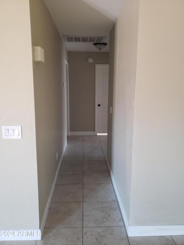 hall with tile patterned floors