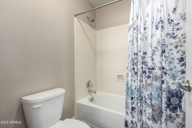 full bathroom with toilet, shower / tub combo, and a textured wall