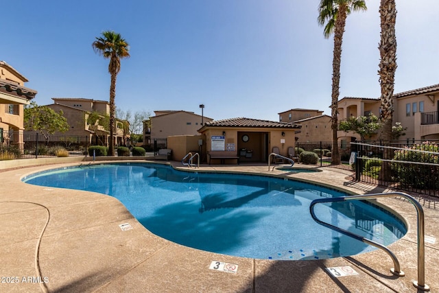 community pool featuring a residential view, a patio area, and fence