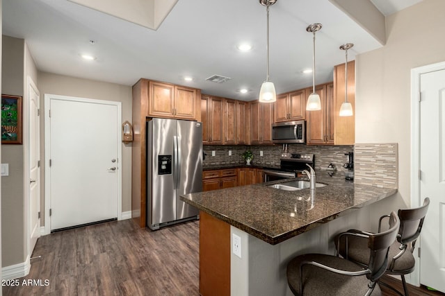 kitchen featuring dark wood finished floors, visible vents, decorative backsplash, appliances with stainless steel finishes, and a peninsula