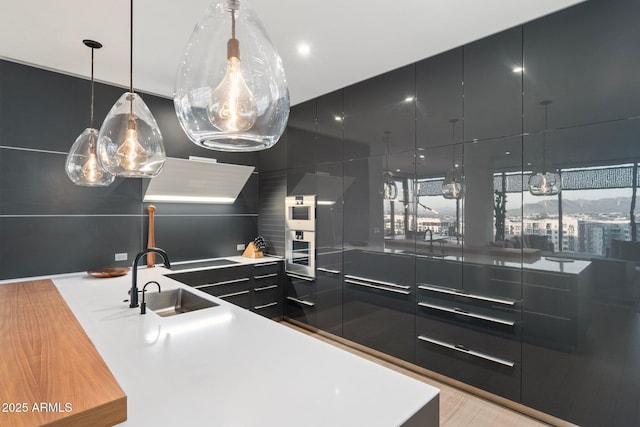 kitchen featuring sink, a center island, hanging light fixtures, and black electric stovetop