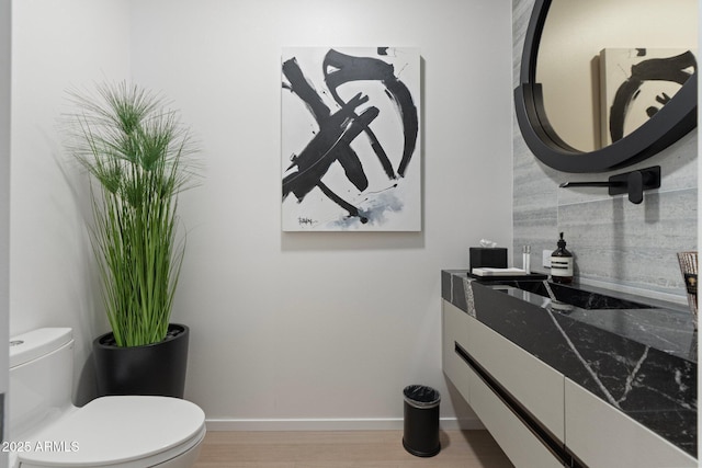 bathroom featuring hardwood / wood-style floors, vanity, and toilet