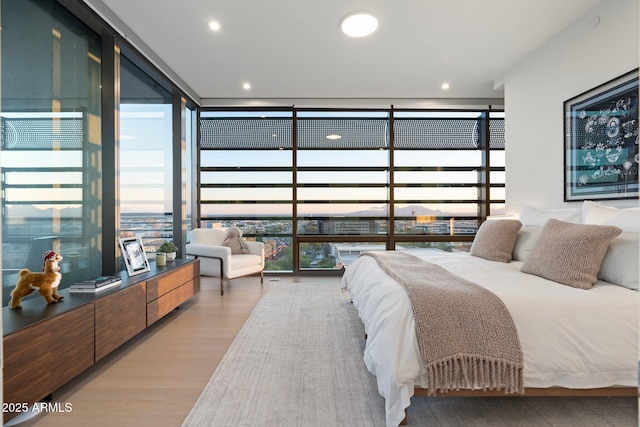 bedroom with light hardwood / wood-style flooring and expansive windows