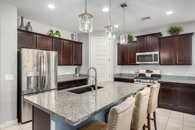 10454 W Maya Way, Peoria, AZ 85383 - kitchen featuring a sink, a kitchen bar, stainless steel appliances, light tile patterned floors, and visible vents