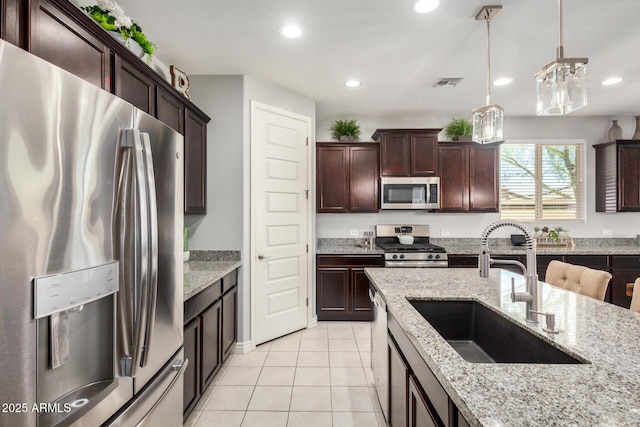 10454 W Maya Way, Peoria, AZ 85383 - kitchen with light tile patterned flooring, visible vents, stainless steel appliances, a sink, and decorative light fixtures