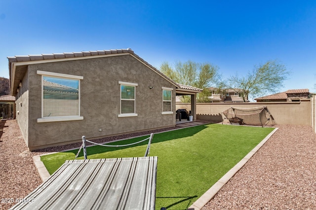 10454 W Maya Way, Peoria, AZ 85383 - exterior space featuring a tiled roof, a fenced backyard, stucco siding, a yard, and a patio area