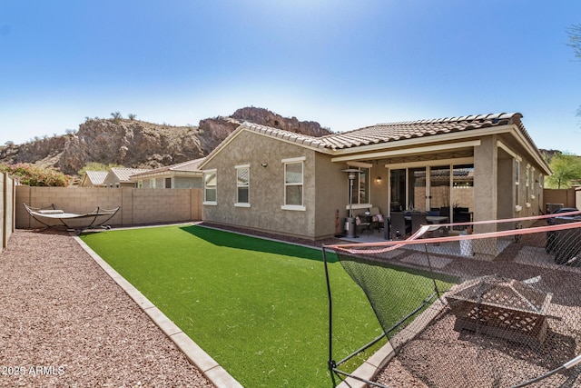 10454 W Maya Way, Peoria, AZ 85383 - back of house featuring an outdoor fire pit, a fenced backyard, stucco siding, and a tiled roof
