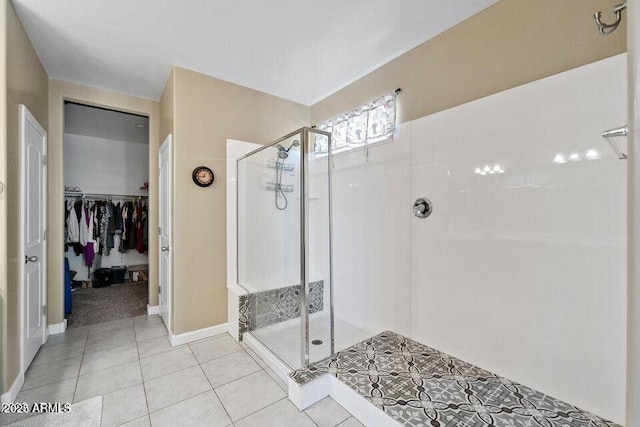 18309 N Crestview Ln, Maricopa, AZ 85138 - full bathroom featuring a shower stall, a walk in closet, tile patterned flooring, and baseboards