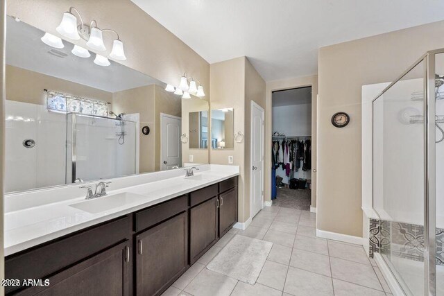 18309 N Crestview Ln, Maricopa, AZ 85138 - bathroom with a stall shower, a spacious closet, double vanity, tile patterned floors, and baseboards