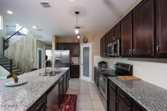 18309 N Crestview Ln, Maricopa, AZ 85138 - kitchen with stainless steel appliances, a sink, light stone counters, dark brown cabinets, and recessed lighting