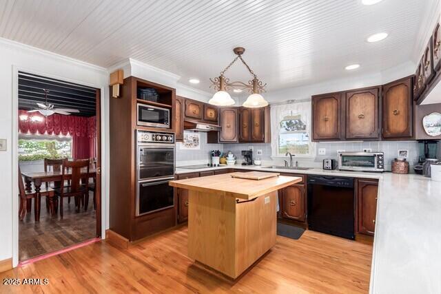 315 N 4th St, Tombstone, AZ 85638 - kitchen featuring a sink, a center island, black appliances, backsplash, and butcher block counters