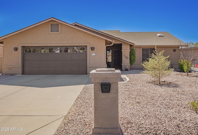 view of front of property featuring a shingled roof, concrete driveway, an attached garage, and stucco siding