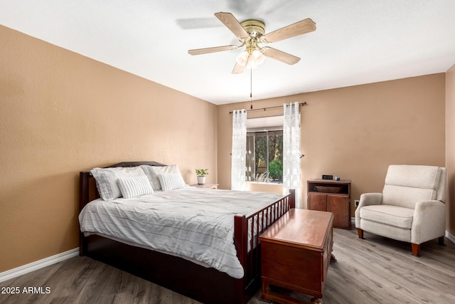 bedroom featuring ceiling fan, wood finished floors, and baseboards