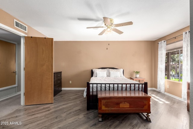 bedroom with dark wood-style floors, visible vents, ceiling fan, and baseboards