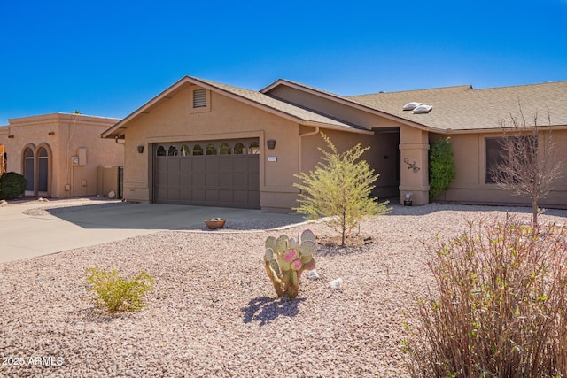 ranch-style home with driveway, an attached garage, and stucco siding