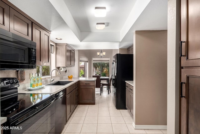 kitchen with light tile patterned floors, a notable chandelier, a sink, light countertops, and black appliances