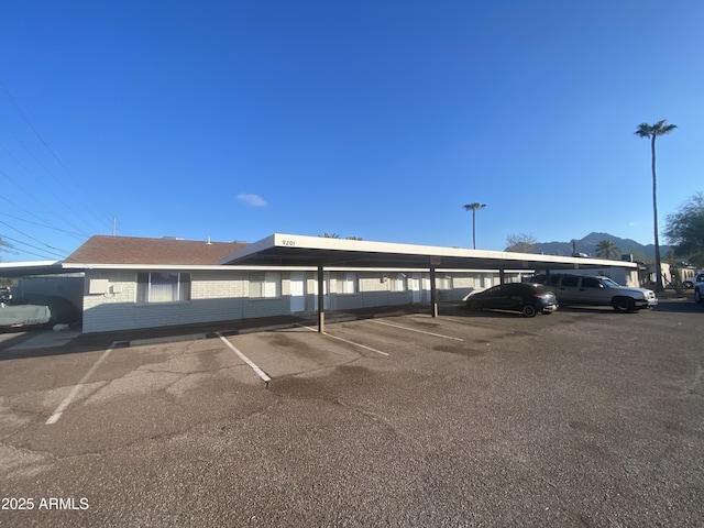 view of car parking featuring a mountain view and a carport