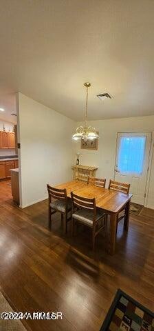 dining area featuring a notable chandelier and dark hardwood / wood-style flooring