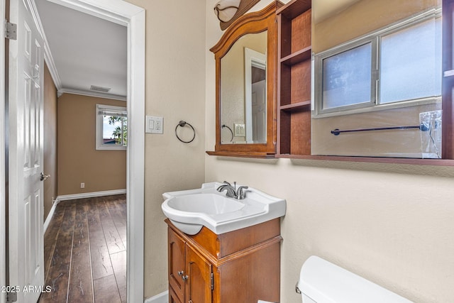 7250 E Mckellips Rd, Scottsdale, AZ 85257 - half bath featuring toilet, vanity, hardwood / wood-style floors, baseboards, and ornamental molding
