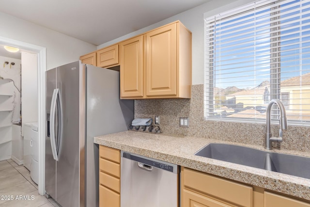 kitchen with light tile patterned flooring, appliances with stainless steel finishes, light brown cabinetry, and sink