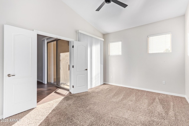 carpeted spare room featuring lofted ceiling and ceiling fan