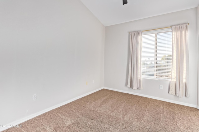 carpeted empty room with vaulted ceiling