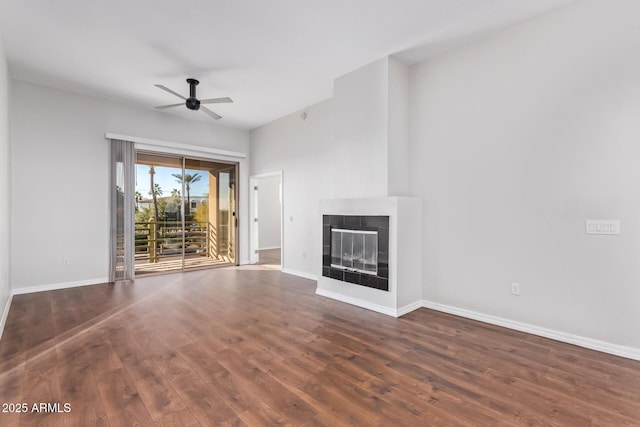 unfurnished living room featuring ceiling fan and dark hardwood / wood-style flooring