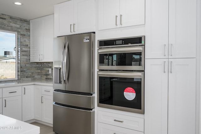 kitchen with white cabinetry, appliances with stainless steel finishes, and backsplash