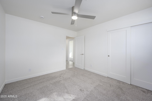 unfurnished bedroom with light carpet, a closet, and ceiling fan